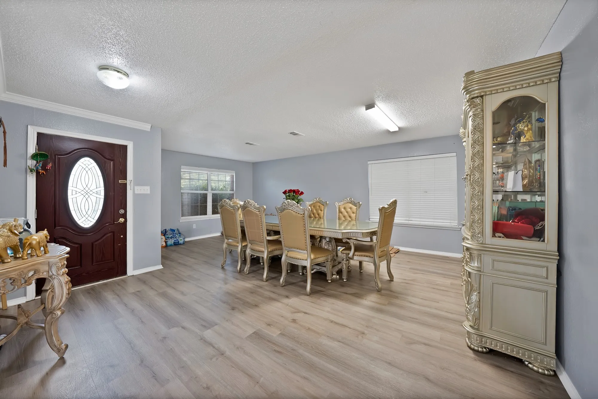 Wood-finish flooring, light blue wall paint, white crown molding, and recessed lighting