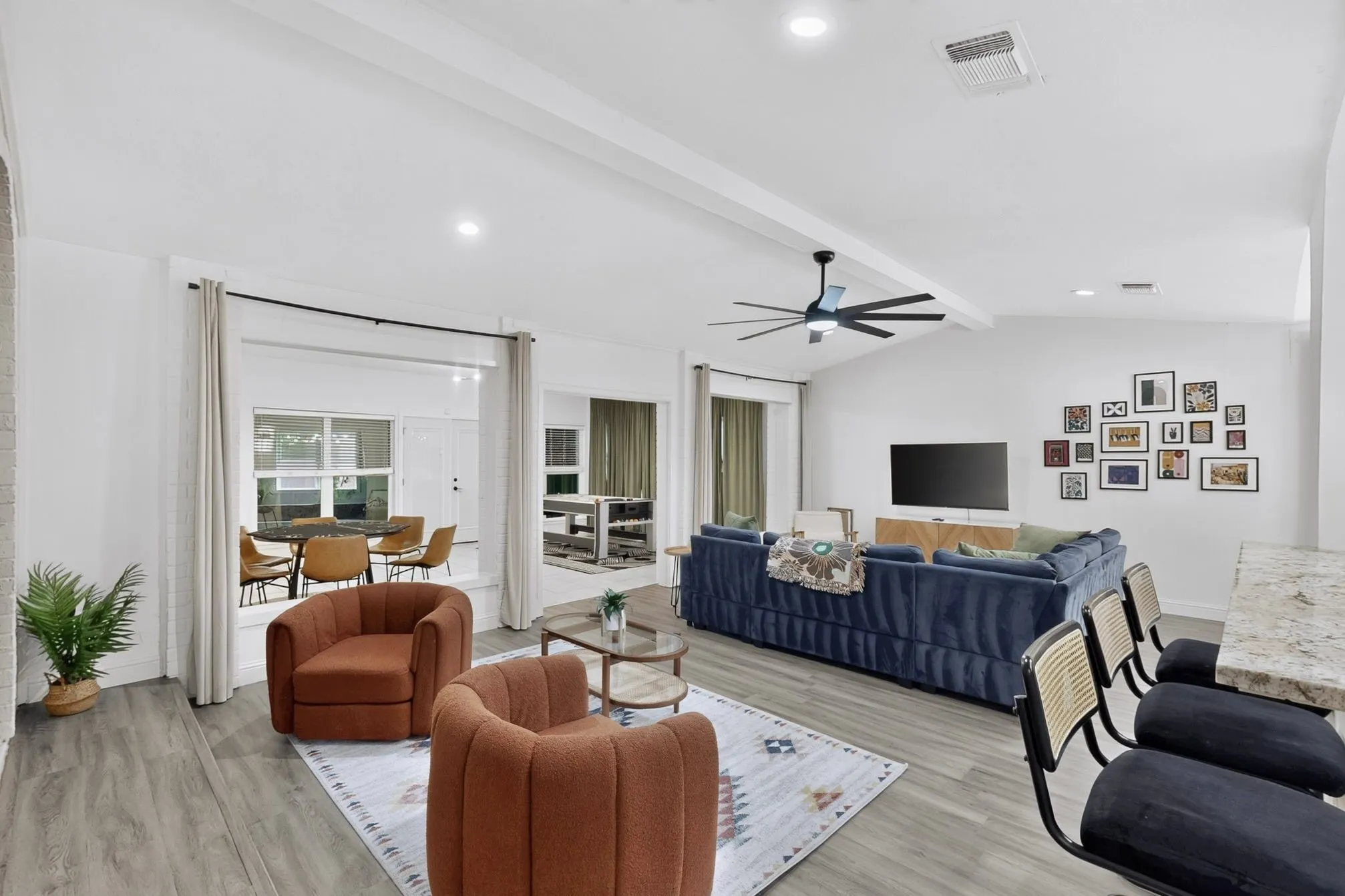 Vaulted ceiling with exposed beams and a ceiling fan, recessed lighting, and wood-finish flooring