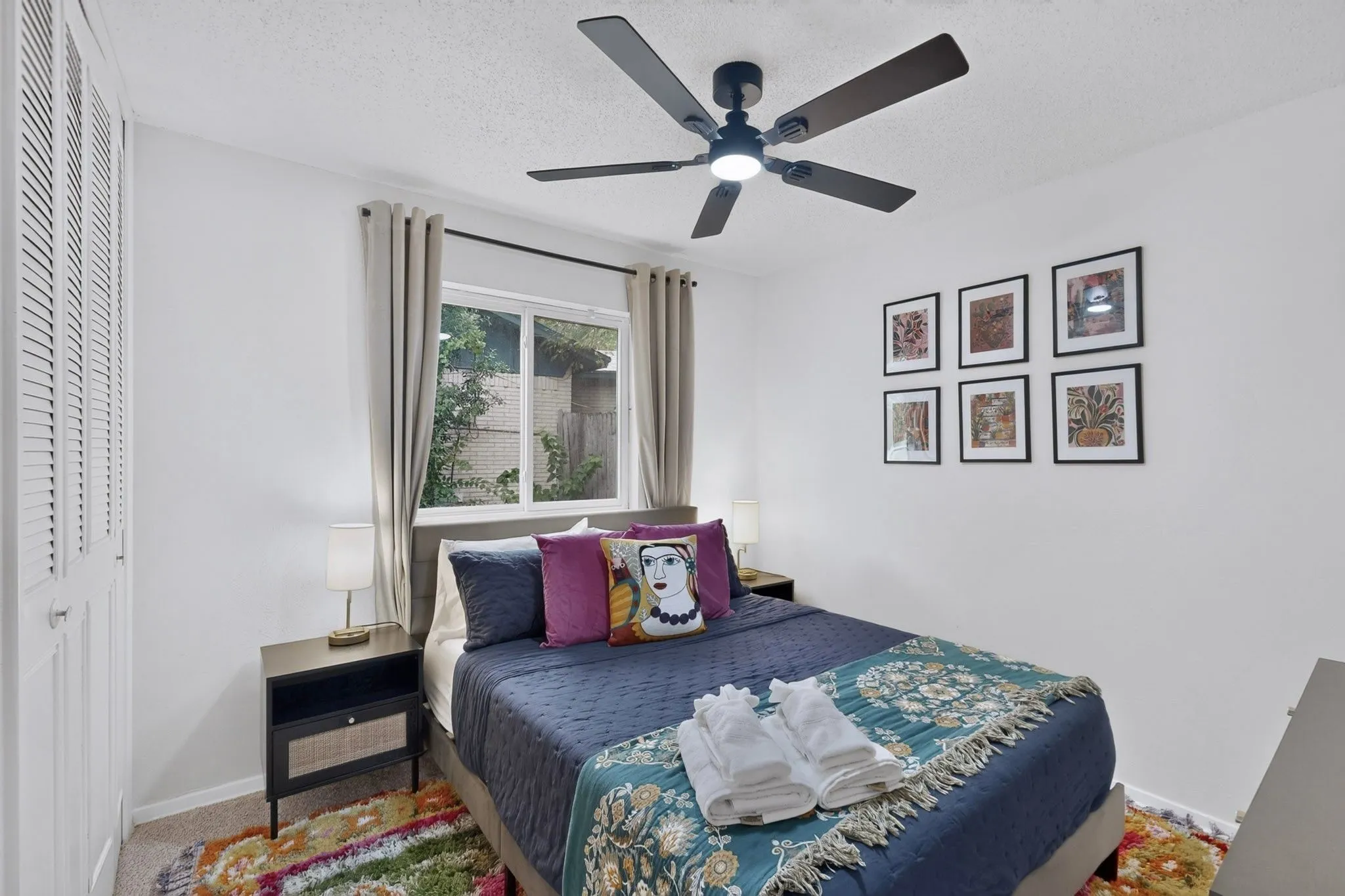 White louvered bi-fold closet doors, multi-pane window, and a ceiling fan with integrated lighting