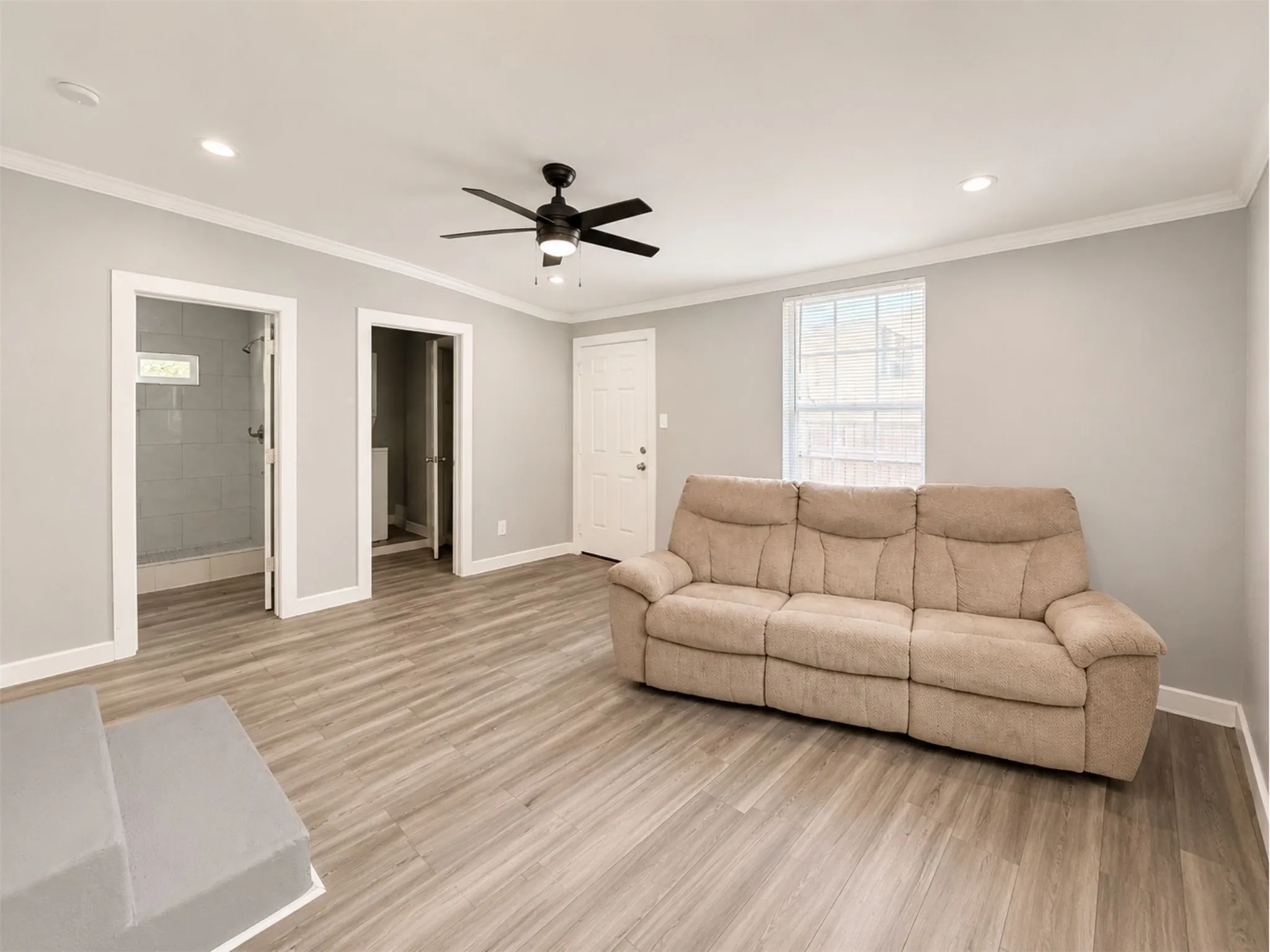 Recessed lighting, wood-finish flooring, ceiling fan, crown molding, and a visible window
