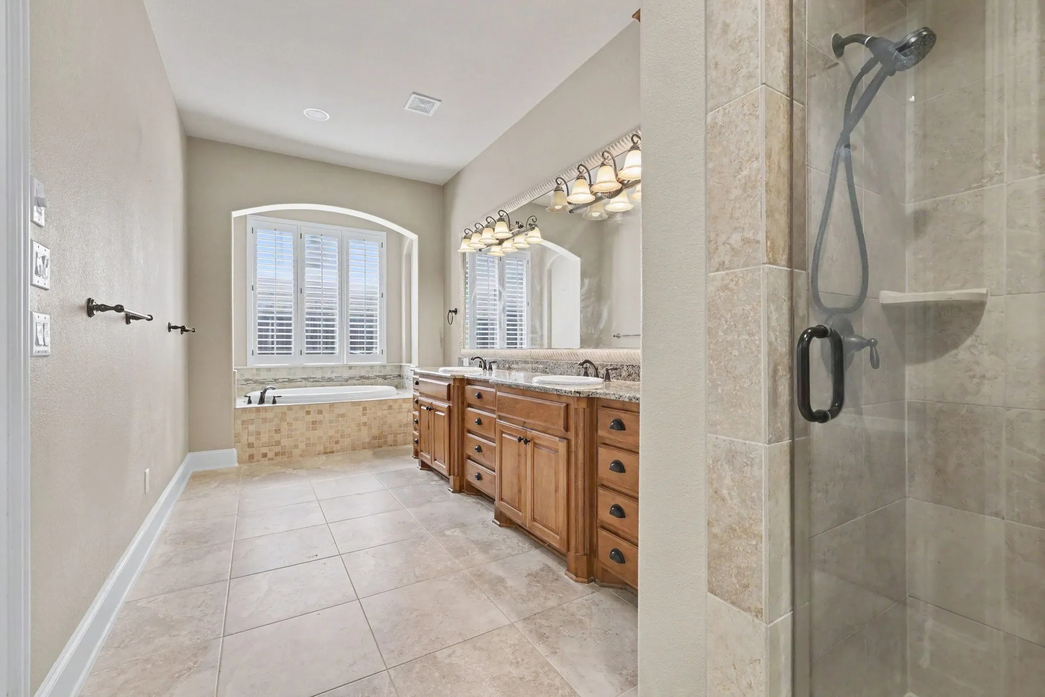 Tile flooring featuring an inset bathtub with a tiled surround