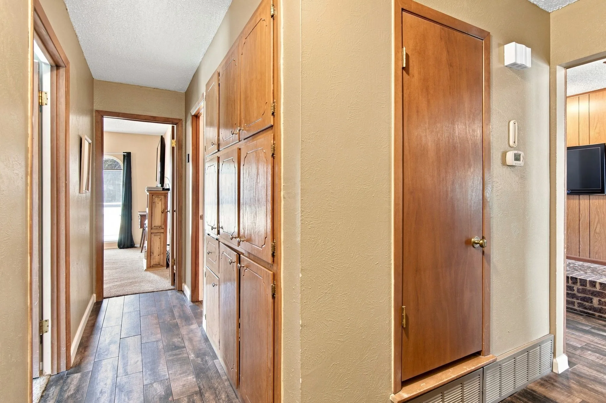 Wood-finish flooring with built-in wood cabinetry and wood paneling