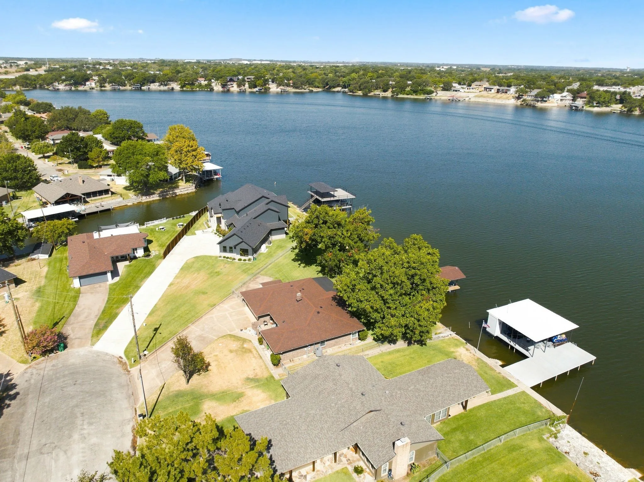 Waterfront property with extensive lake frontage, private boat dock, and lush green lawns