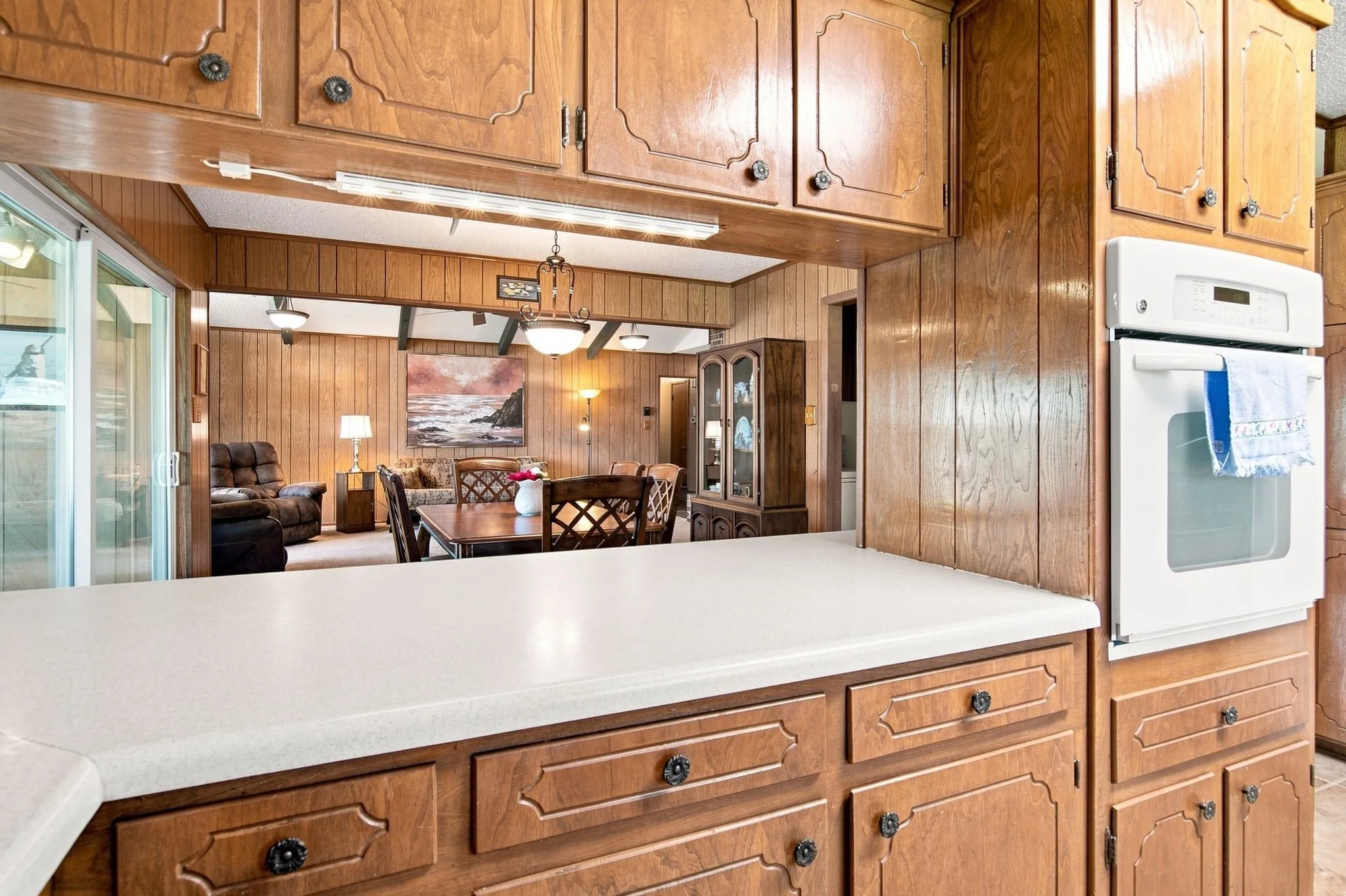 White countertop with built-in oven and wood cabinetry