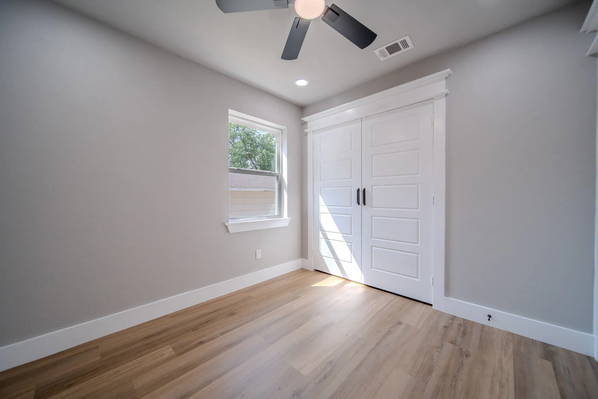 Wood-finish flooring, white trim, recessed lighting, and a ceiling fan with light fixture