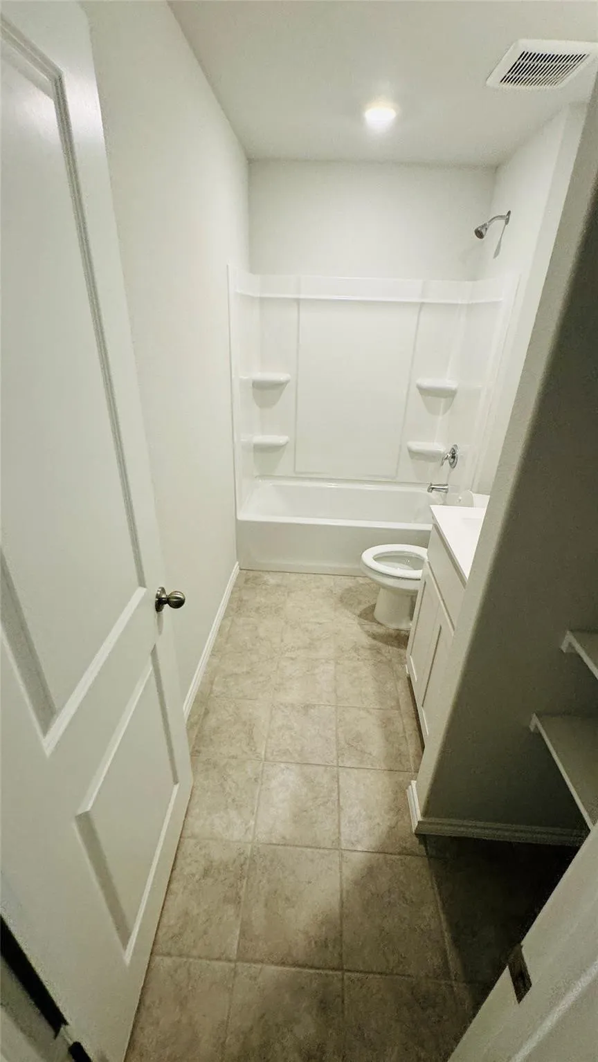 Full bathroom featuring a white tub, shower fixture, and a single vanity with a white countertop