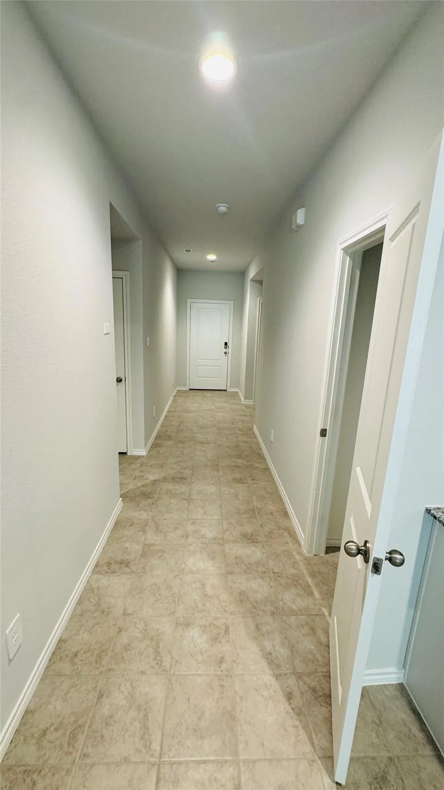Hallway featuring tile flooring, neutral wall tones, and recessed lighting