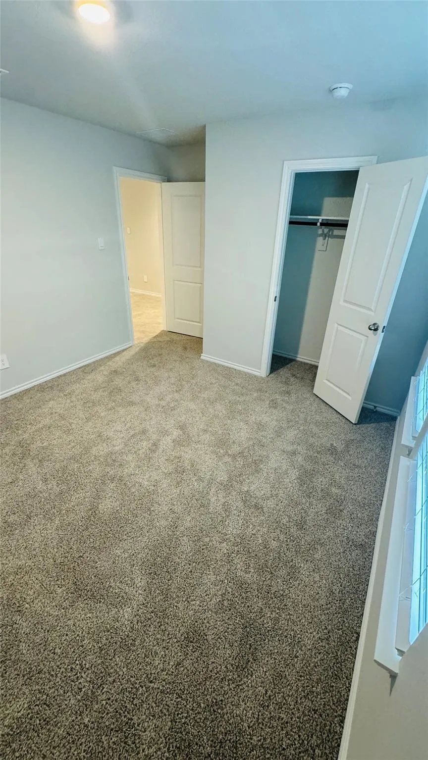 Plush carpeting, recessed lighting, white interior doors, and a closet with hanging rod