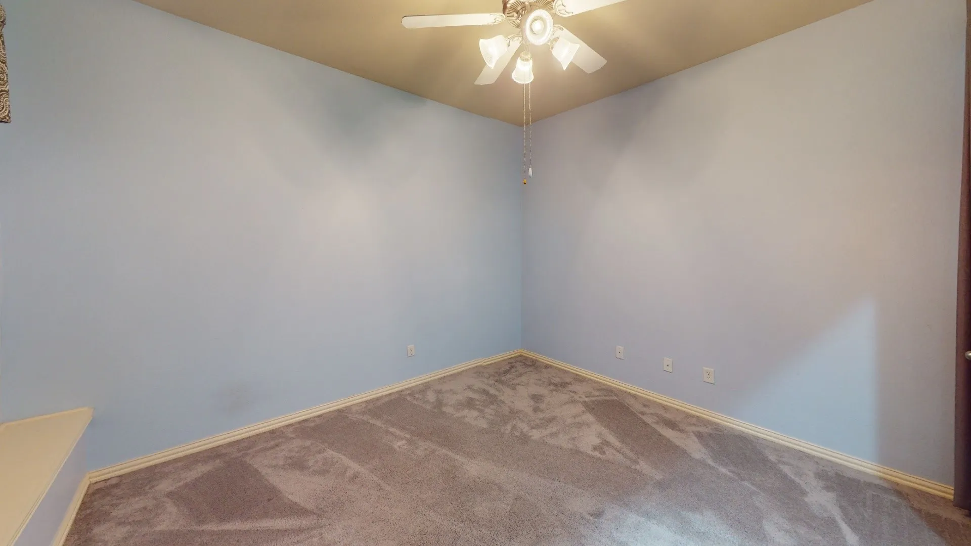 Vaulted ceiling with a ceiling fan, light blue walls, and patterned carpeting