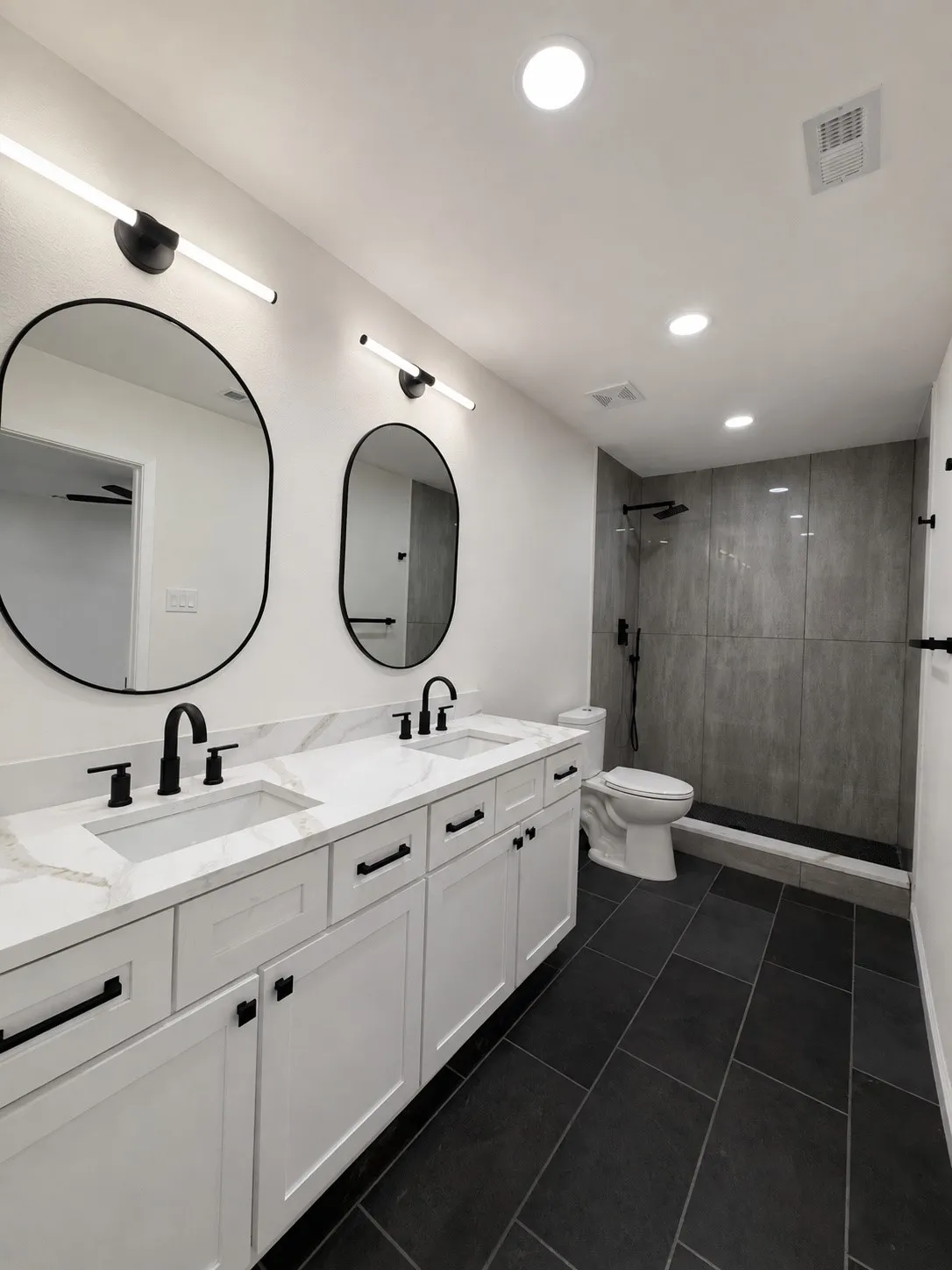 Dual vanity with white shaker-style cabinetry, white countertops, and matte black hardware
