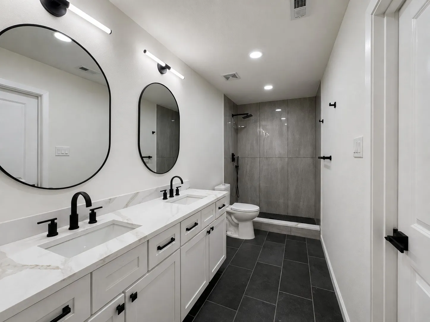 Dual vanity with white shaker cabinetry, integrated rectangular sinks, and matte black fixtures