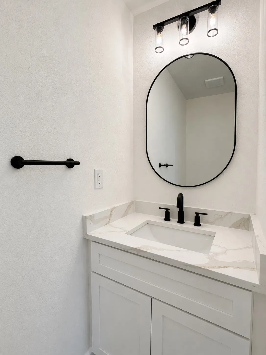 White shaker-style vanity with an integrated rectangular sink and a marble-finish countertop