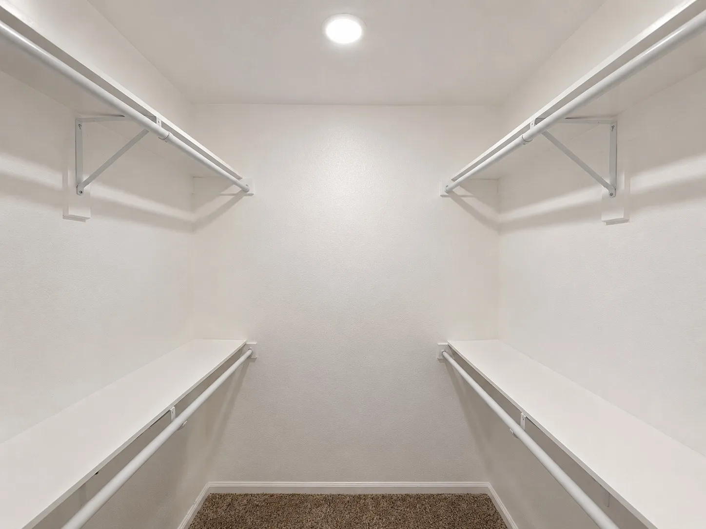 Built-in storage shelves and hanging rods, recessed ceiling lighting, and textured wall finishes