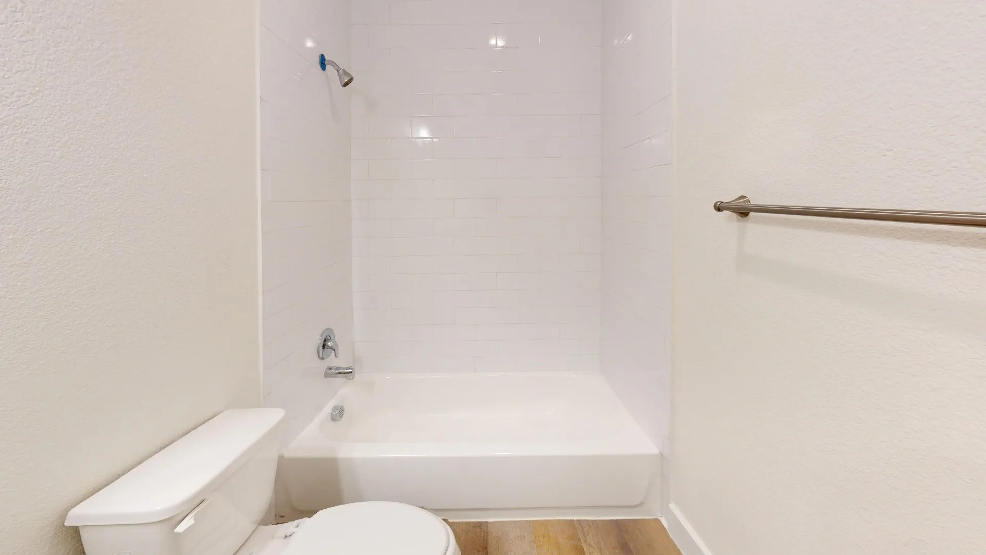 White subway tile shower surround with a built-in tub and chrome fixtures