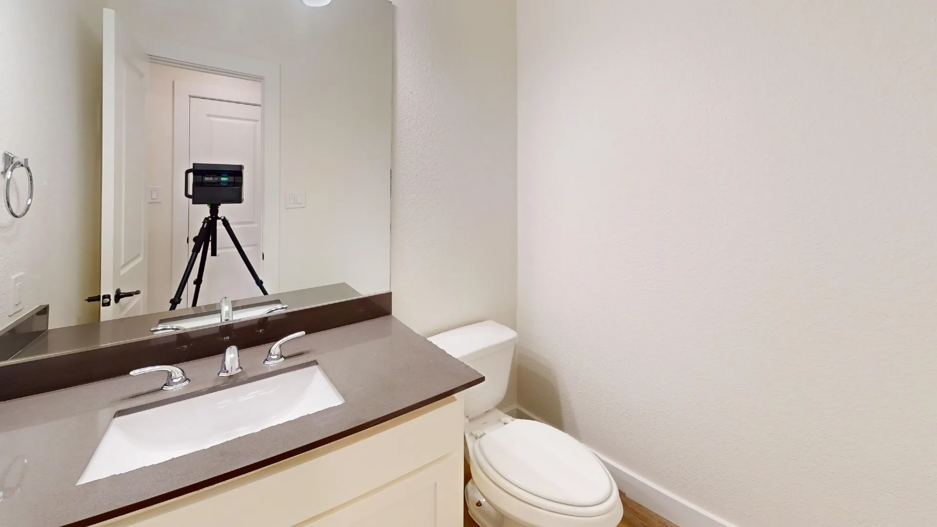 Integrated vanity with a rectangular sink, polished chrome faucet, and expansive wall-mounted mirror
