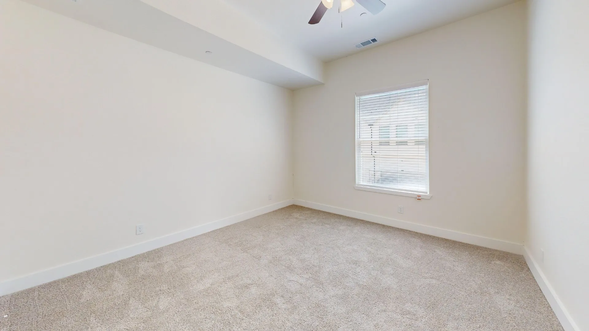 Carpeted room featuring a window with blinds, a ceiling fan, and recessed lighting