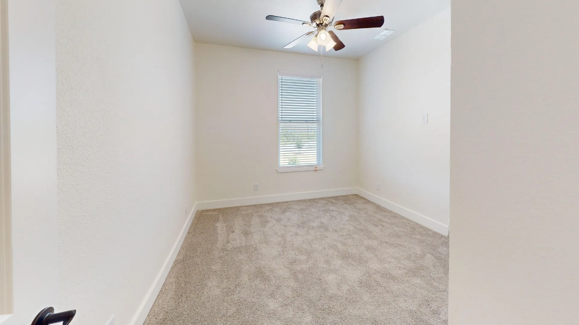 Recessed window with horizontal blinds, ceiling fan with integrated lighting, and neutral carpeting