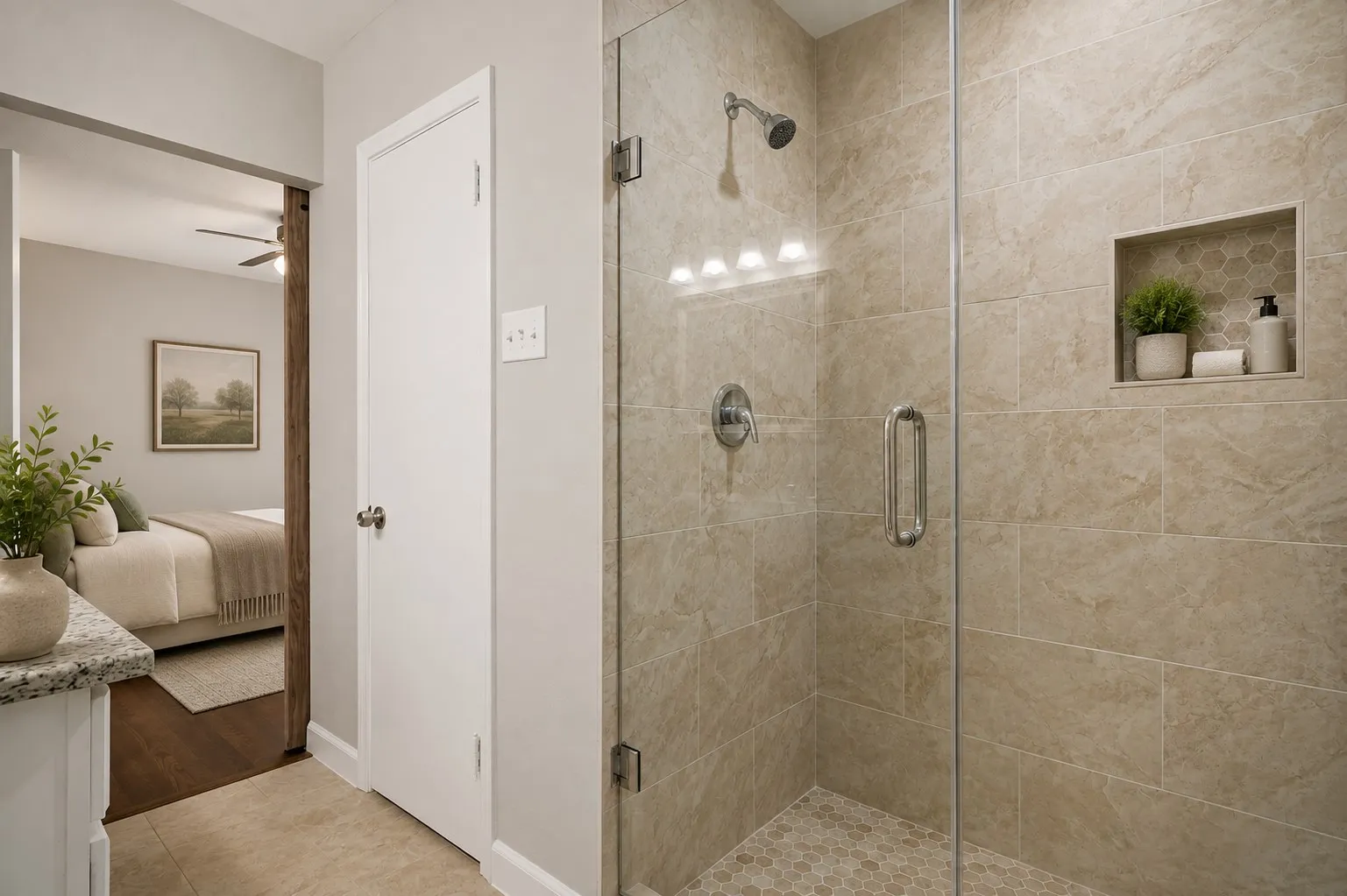 Glass-enclosed shower with stone-finish wall tile, hexagonal floor tile, and a recessed shower niche