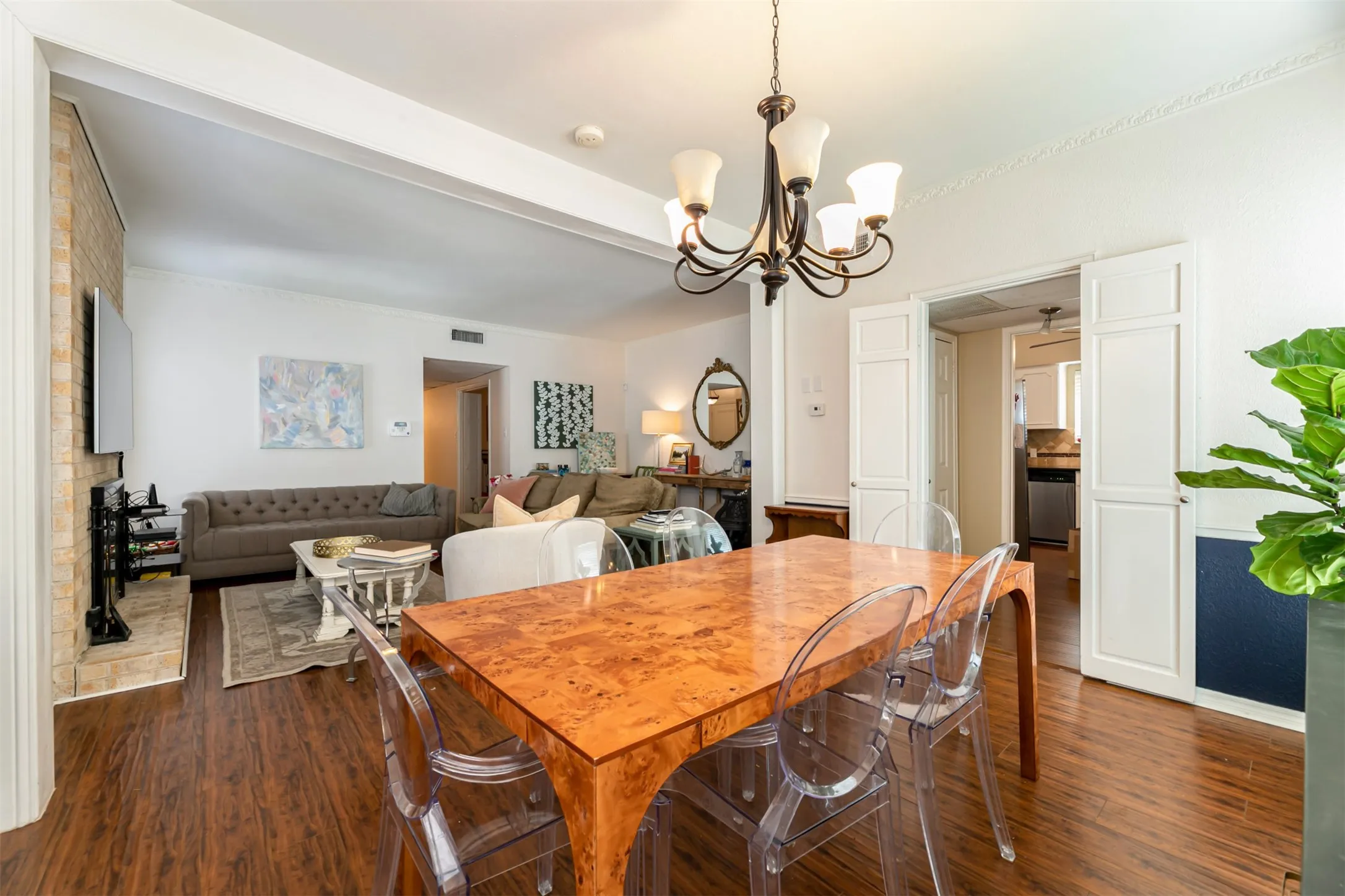 Wood-finish flooring throughout, with a recessed ceiling and a decorative chandelier