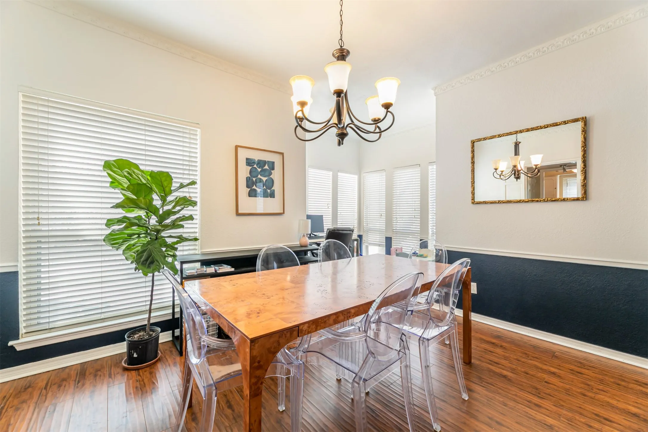 Tray ceiling with crown molding, wood-finish flooring, and a chandelier
