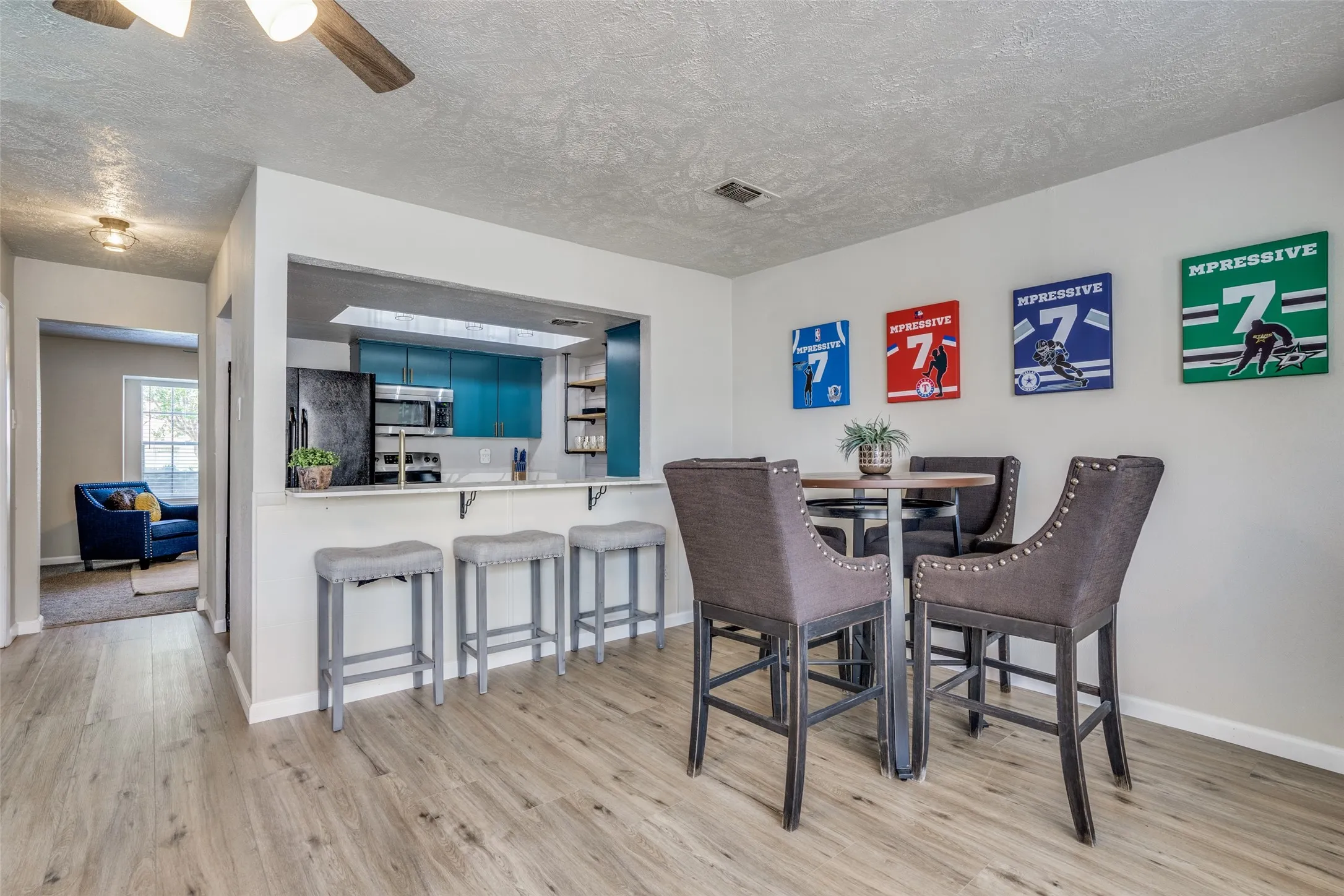 Wood-finish flooring throughout, a kitchen pass-through with a built-in breakfast bar, and recessed lighting
