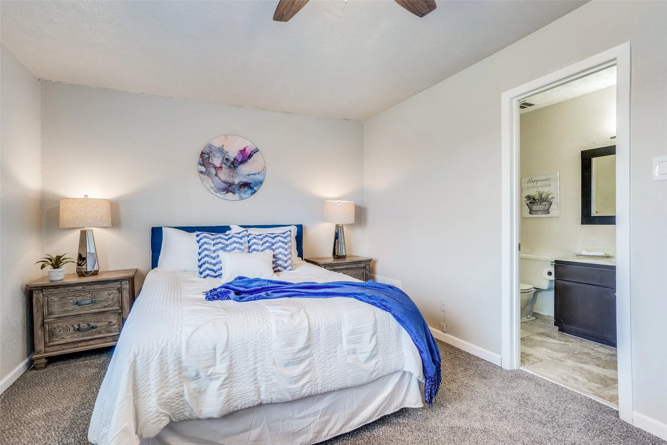 Plush carpeting, light wall tones, and a ceiling fan