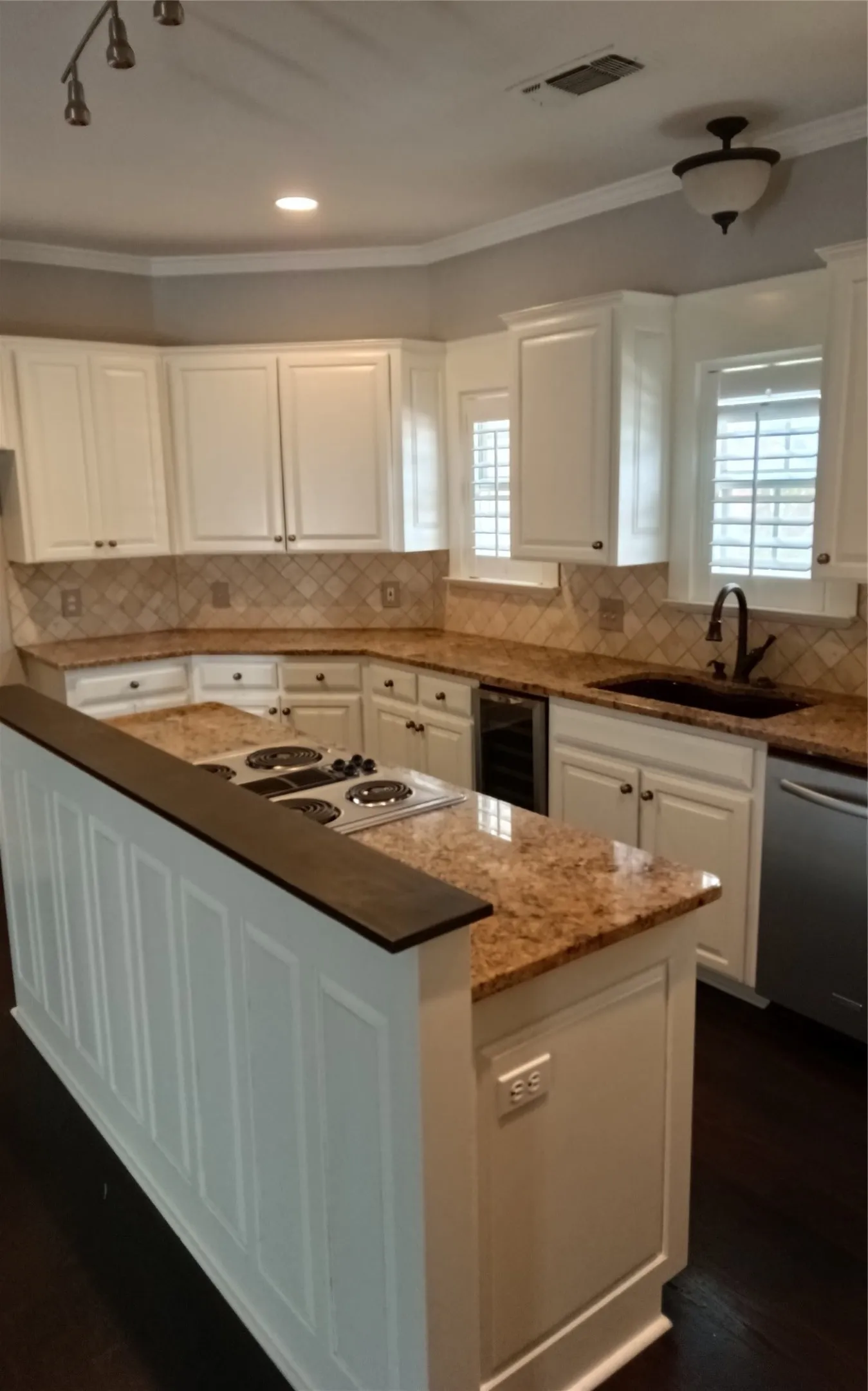 Kitchen featuring white cabinetry, stone countertops, a tile backsplash, and dark wood-finish flooring