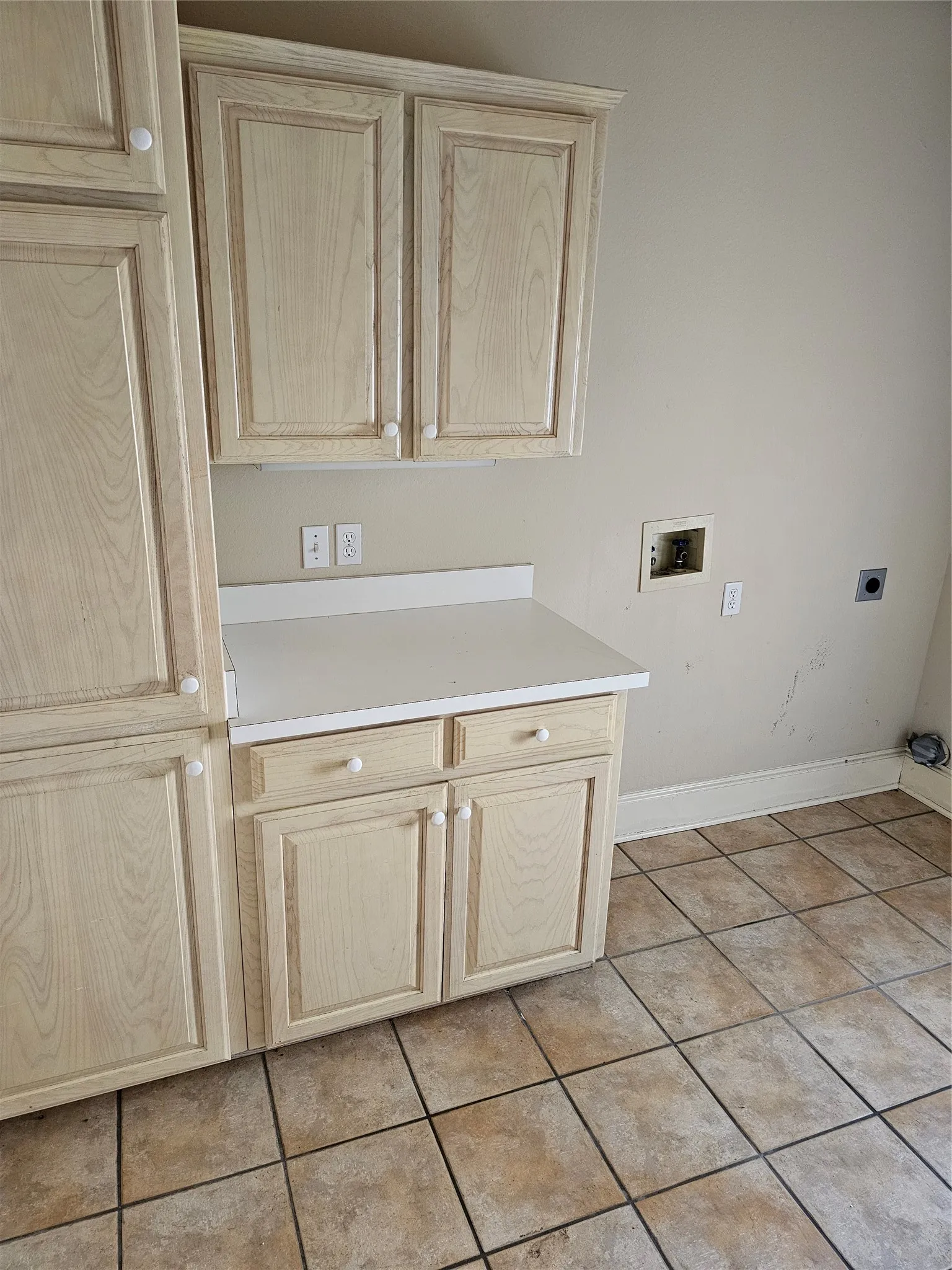 Light wood-finish cabinetry with white knob hardware