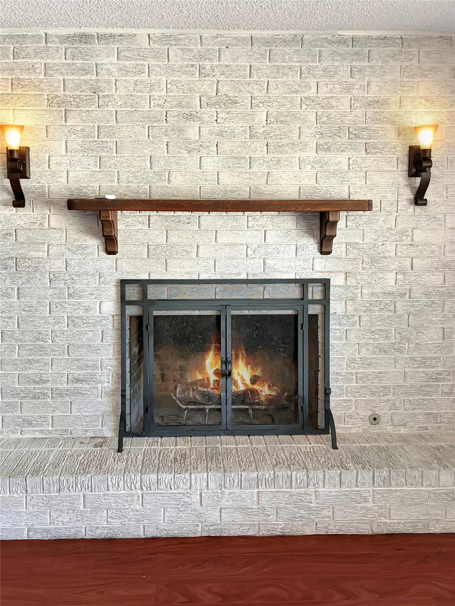 White-painted brick fireplace featuring a wood mantel