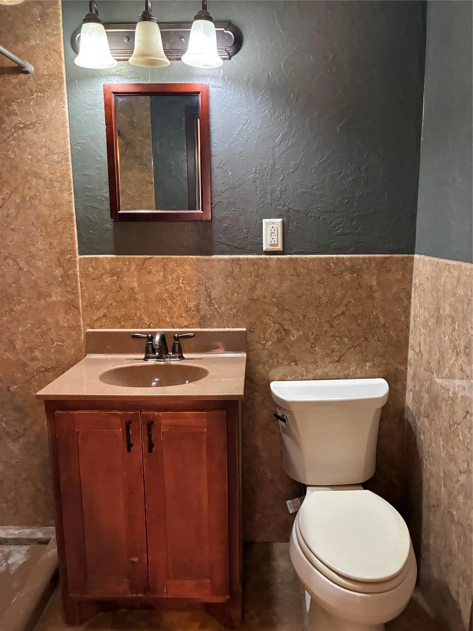 Wood-finish vanity with an integrated sink and bronze-finish faucet