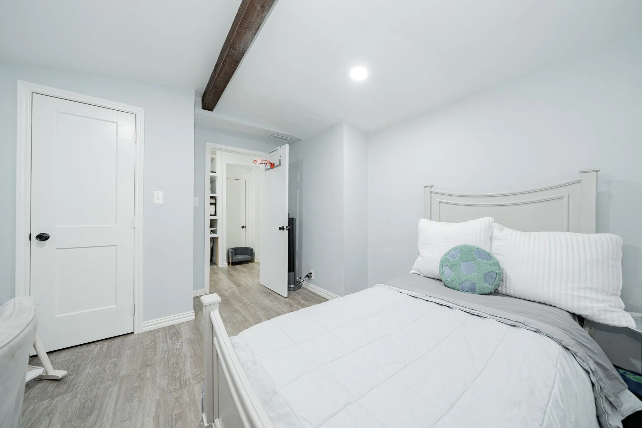 Bedroom with light wood-style flooring, beamed ceiling, and recessed lighting
