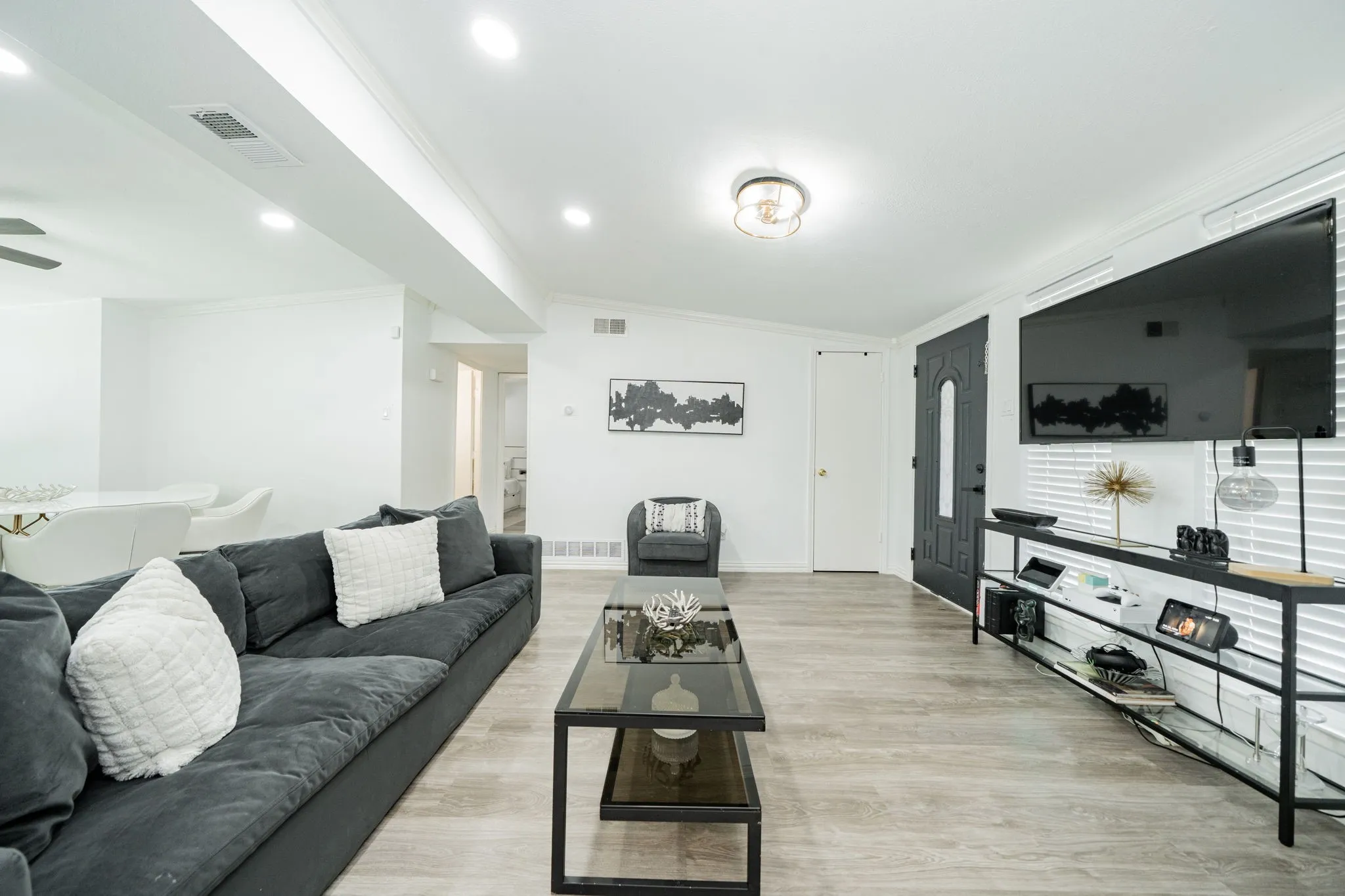Living room featuring crown molding, light wood-style flooring, and recessed lighting