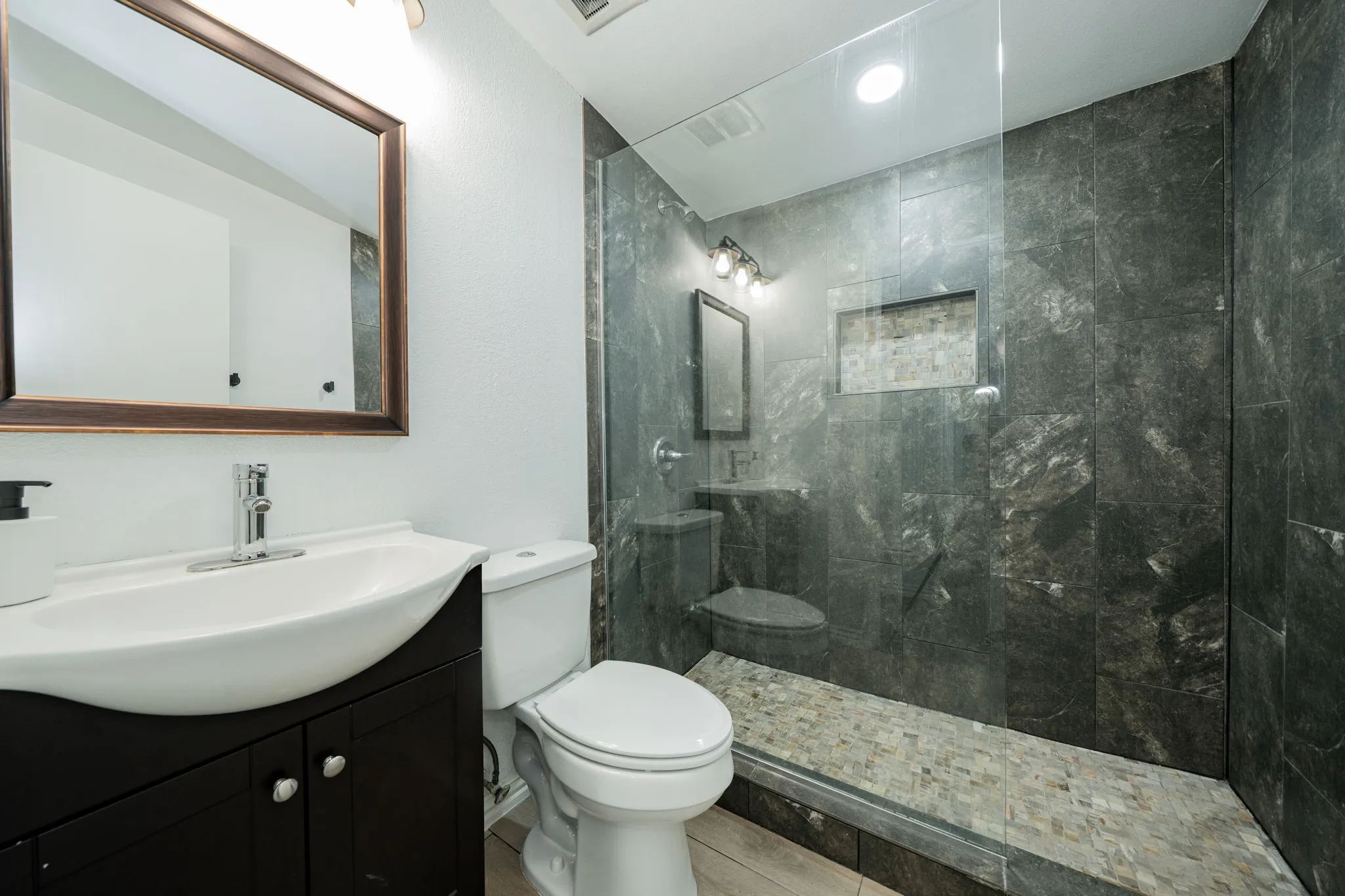 Bathroom featuring vanity, walk in shower, and tile patterned floors