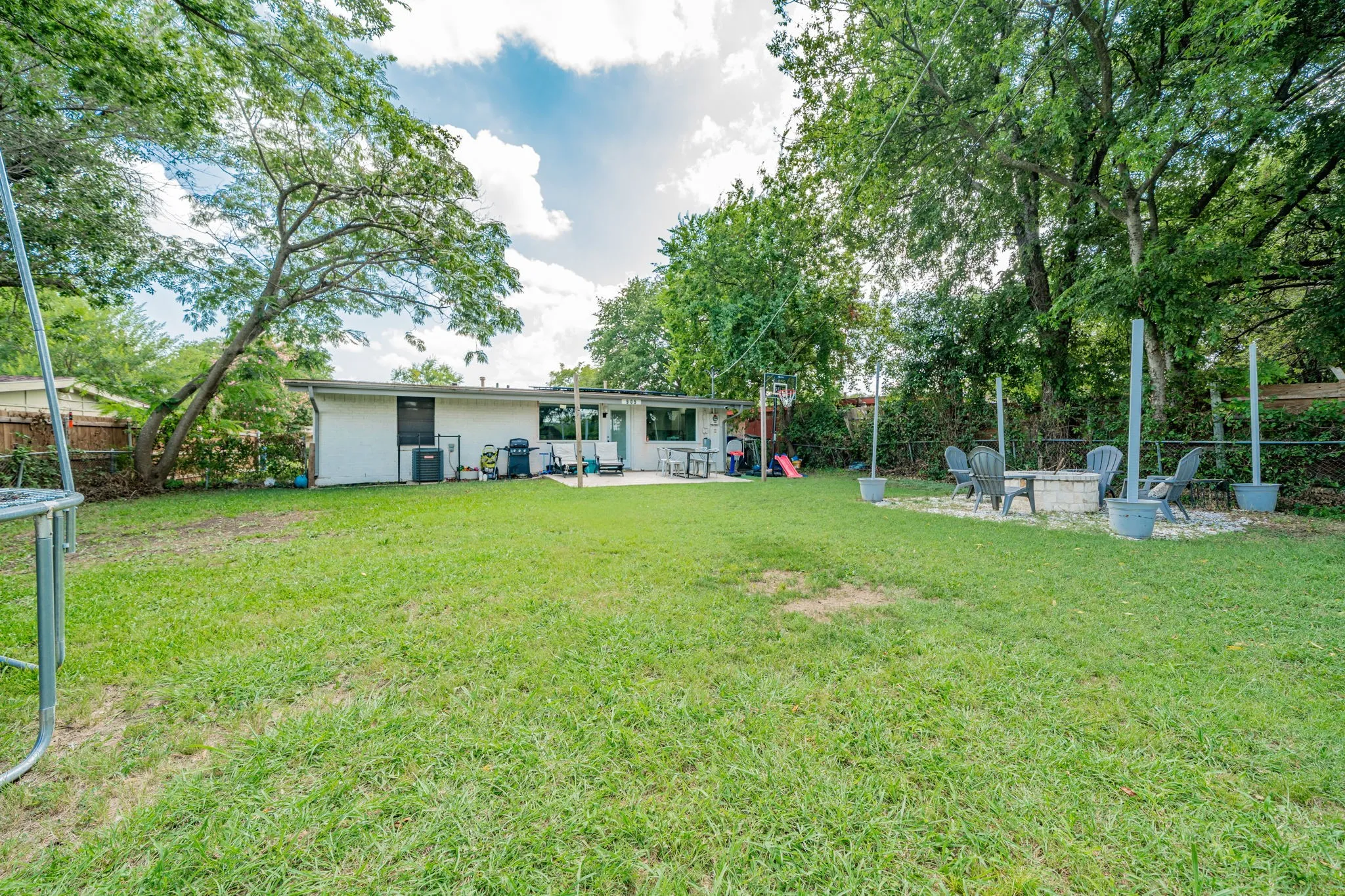 Fenced backyard featuring an outdoor fire pit and a patio area