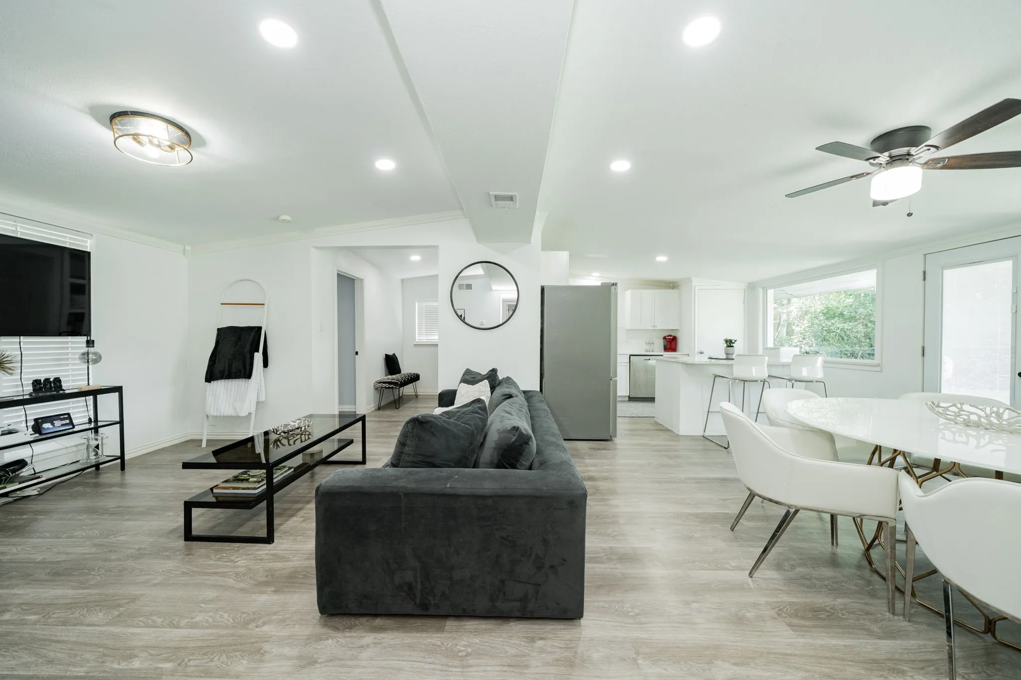 Living area with ceiling fan, light wood-style floors, and recessed lighting