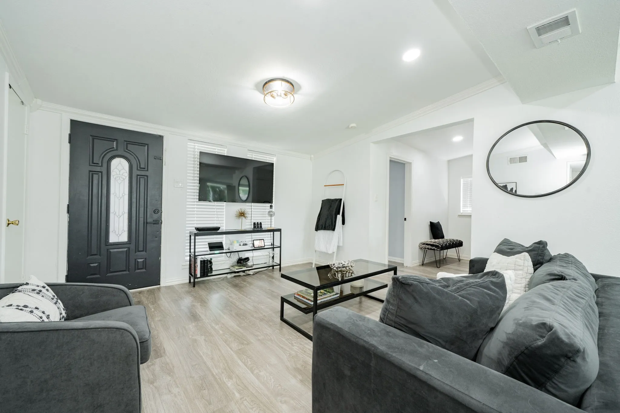 Living room with ornamental molding and light wood-type flooring