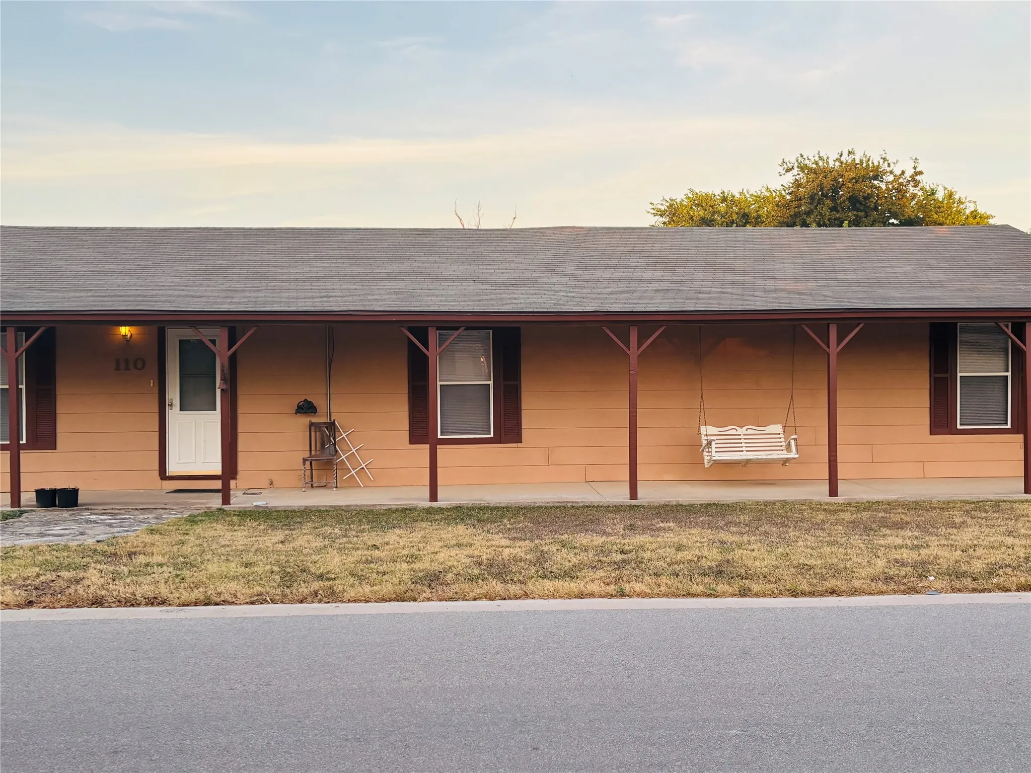 Covered front porch with wood-finish posts and a shingle roof