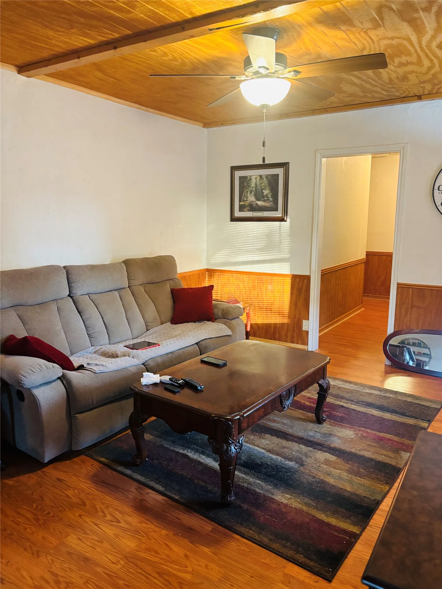 Wood-finish flooring throughout, wood-paneled ceiling, and wood wainscoting