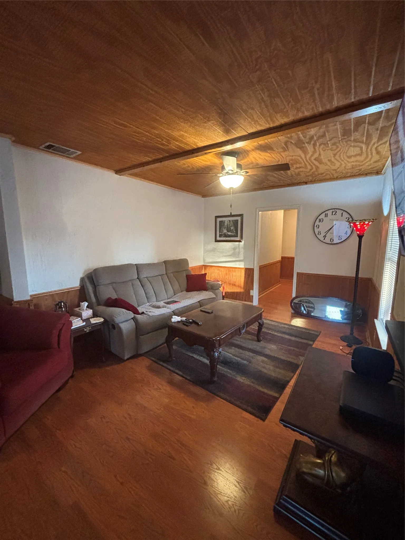 Wood-finish flooring throughout, complemented by wood-paneled walls and a wood-paneled ceiling