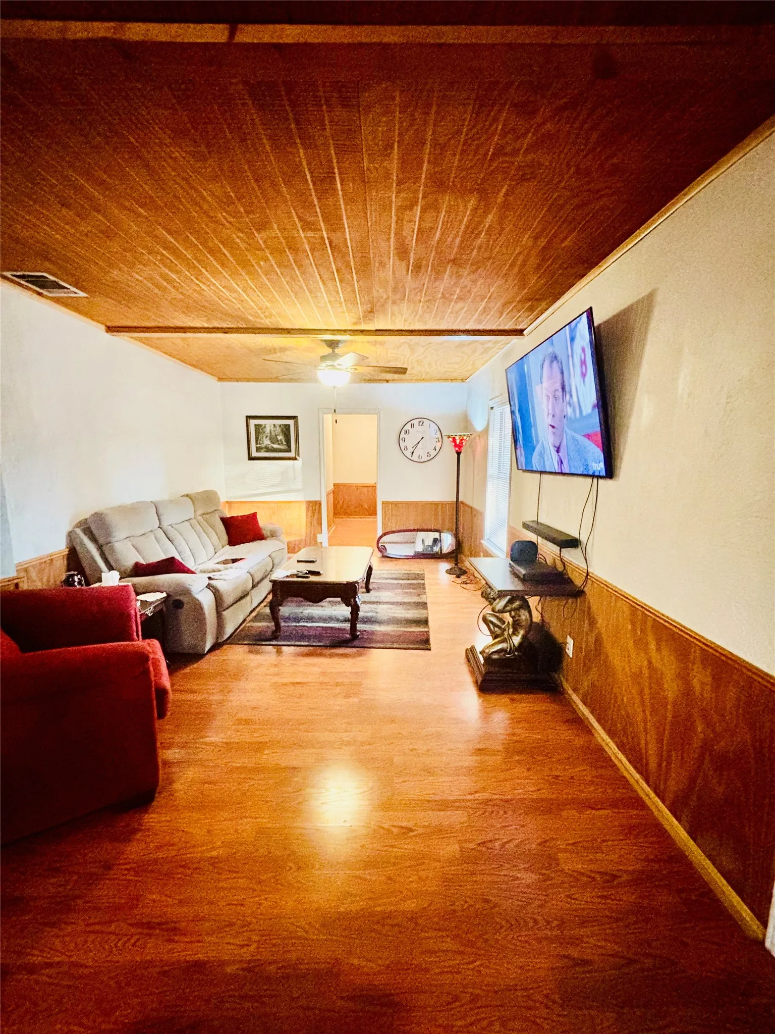 Wood-finish flooring, wood paneling, wood-paneled ceiling, and ceiling fan