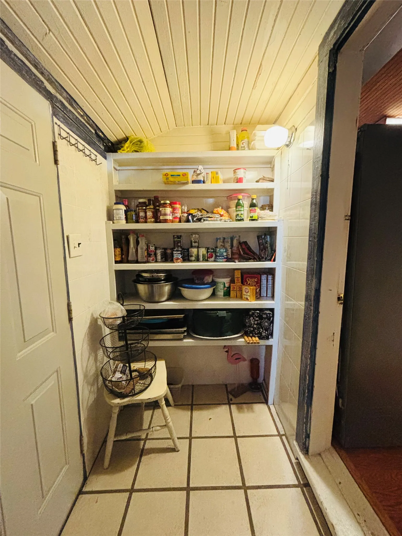 Built-in shelving for organized storage, tile flooring, and overhead lighting
