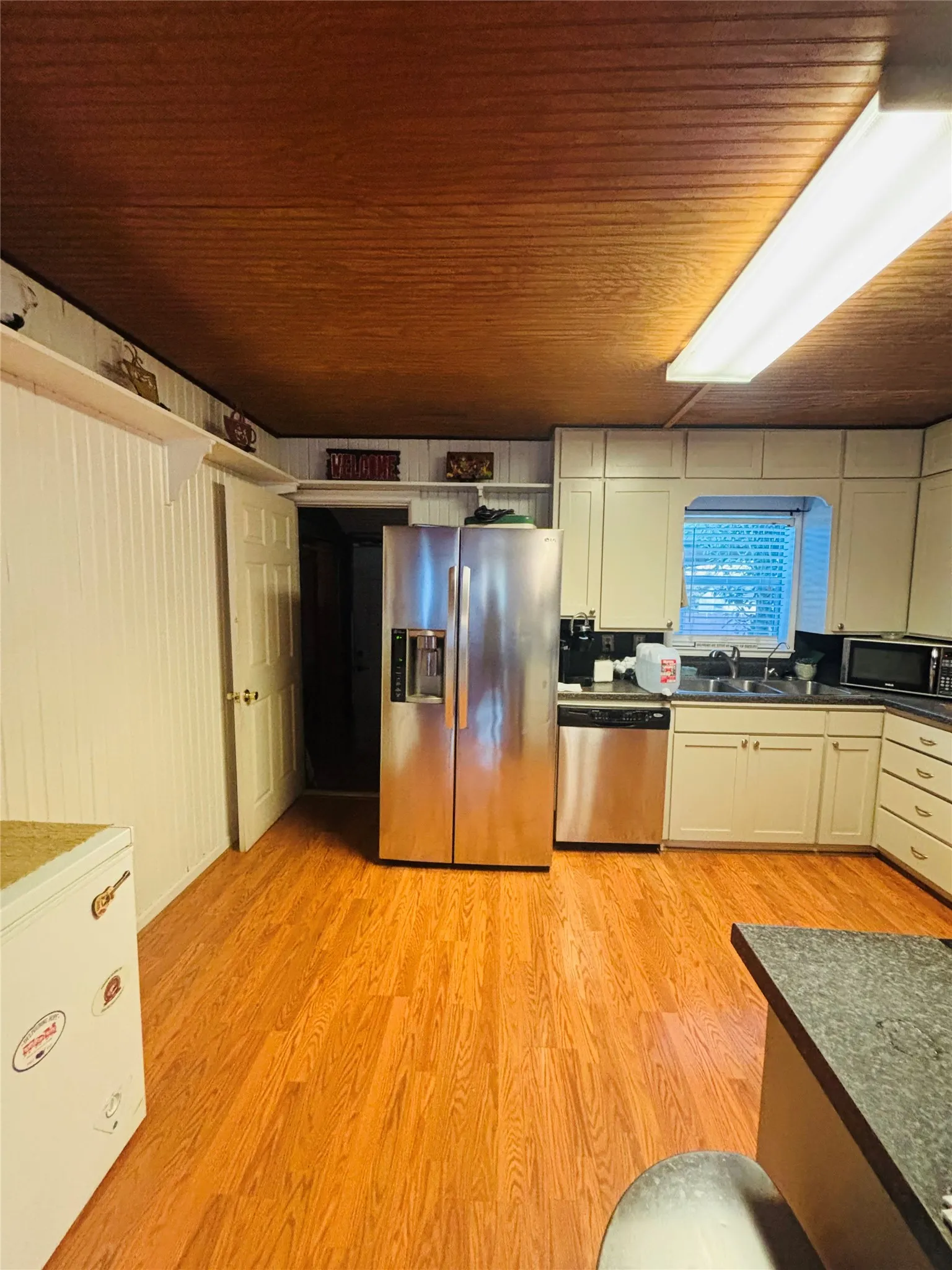 Wood-finish flooring with a wood plank ceiling and white beadboard paneling