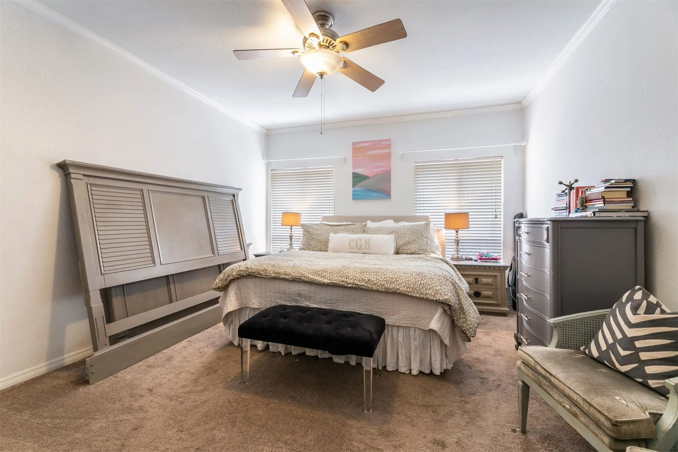 Ceiling fan with integrated lighting, crown molding, two windows with blinds, and carpeted flooring