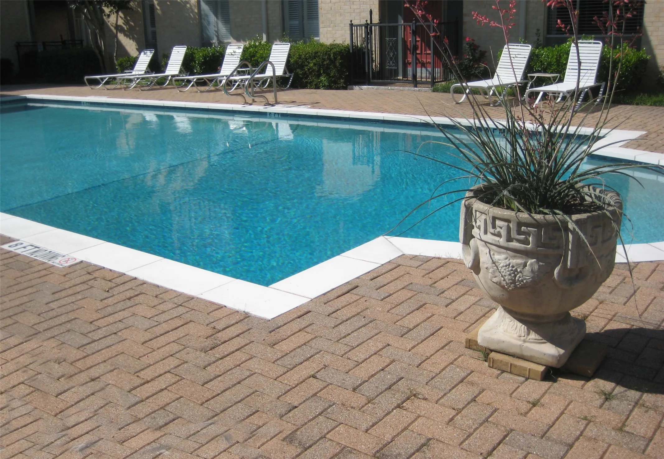 Swimming pool with a brick paver surround and white coping
