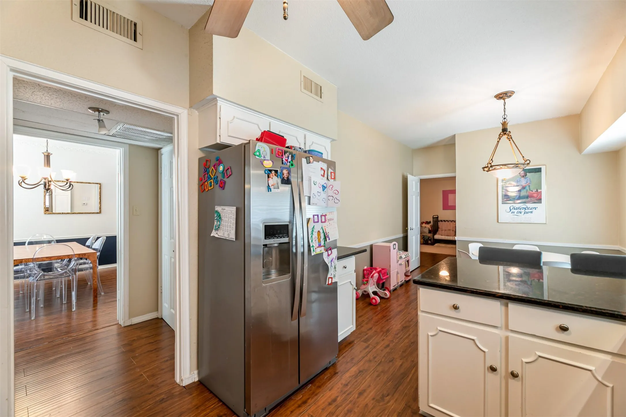 Kitchen featuring wood-finish flooring, white cabinetry, and dark countertops