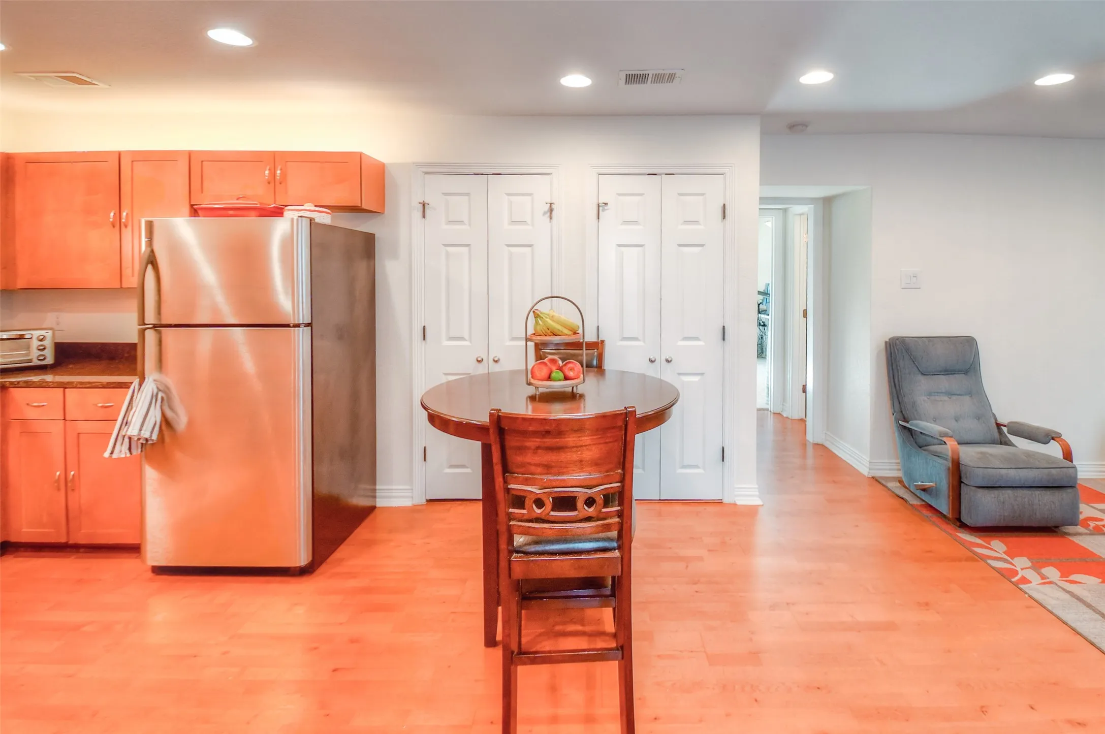 Kitchen featuring light wood-type flooring, freestanding refrigerator, visible vents, and recessed lighting
