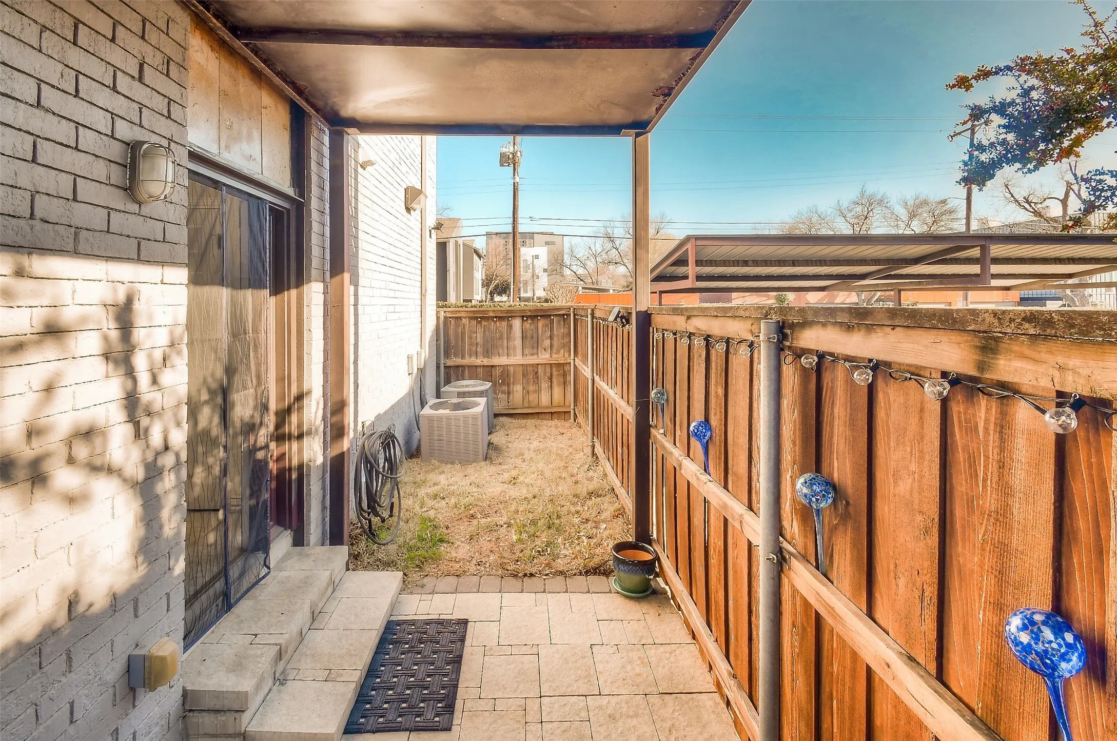 View of patio featuring central AC unit and fence