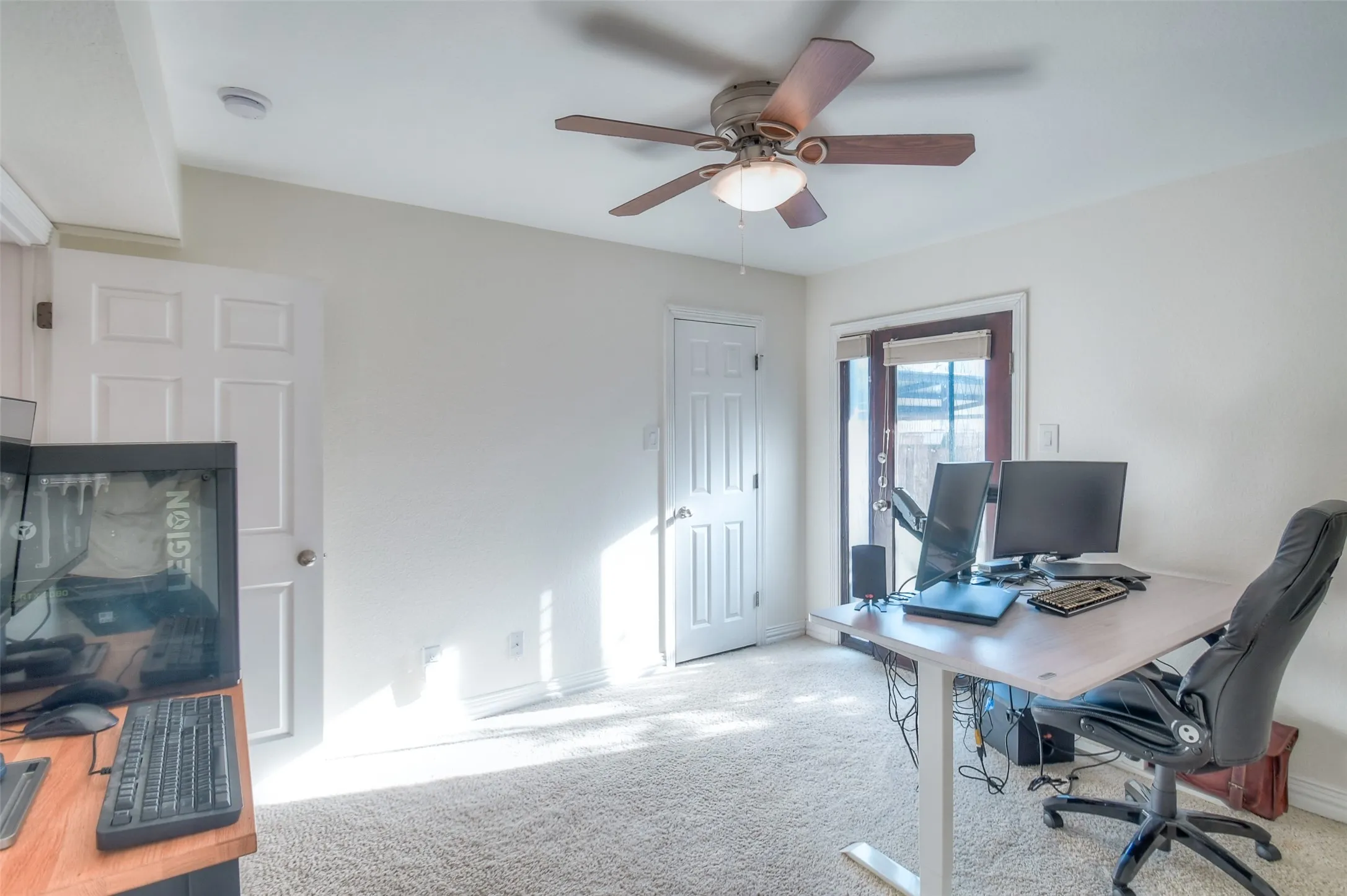 Office space with carpet floors, a ceiling fan, and baseboards