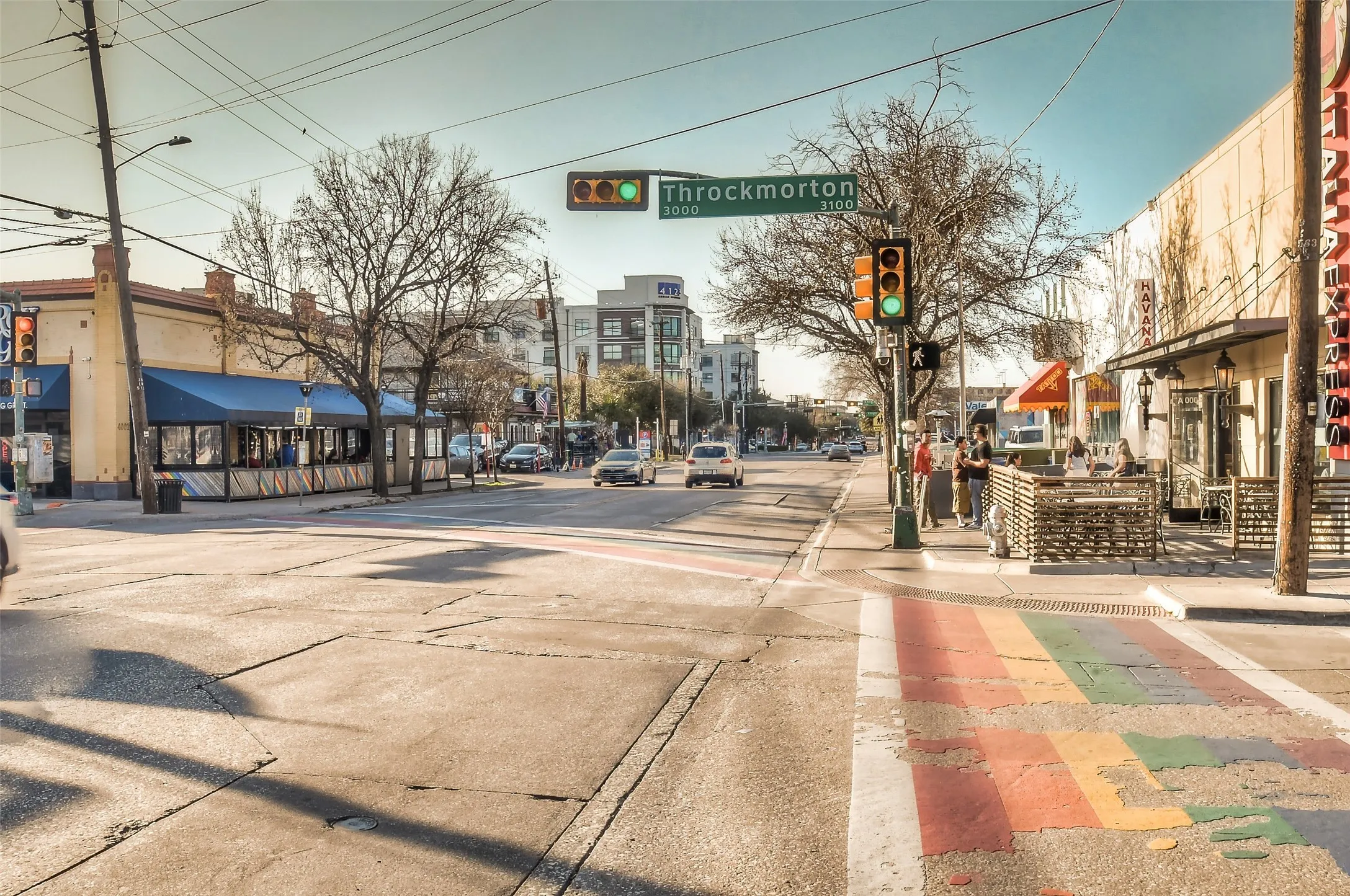 View of road featuring sidewalks, traffic lights, street lighting, and curbs