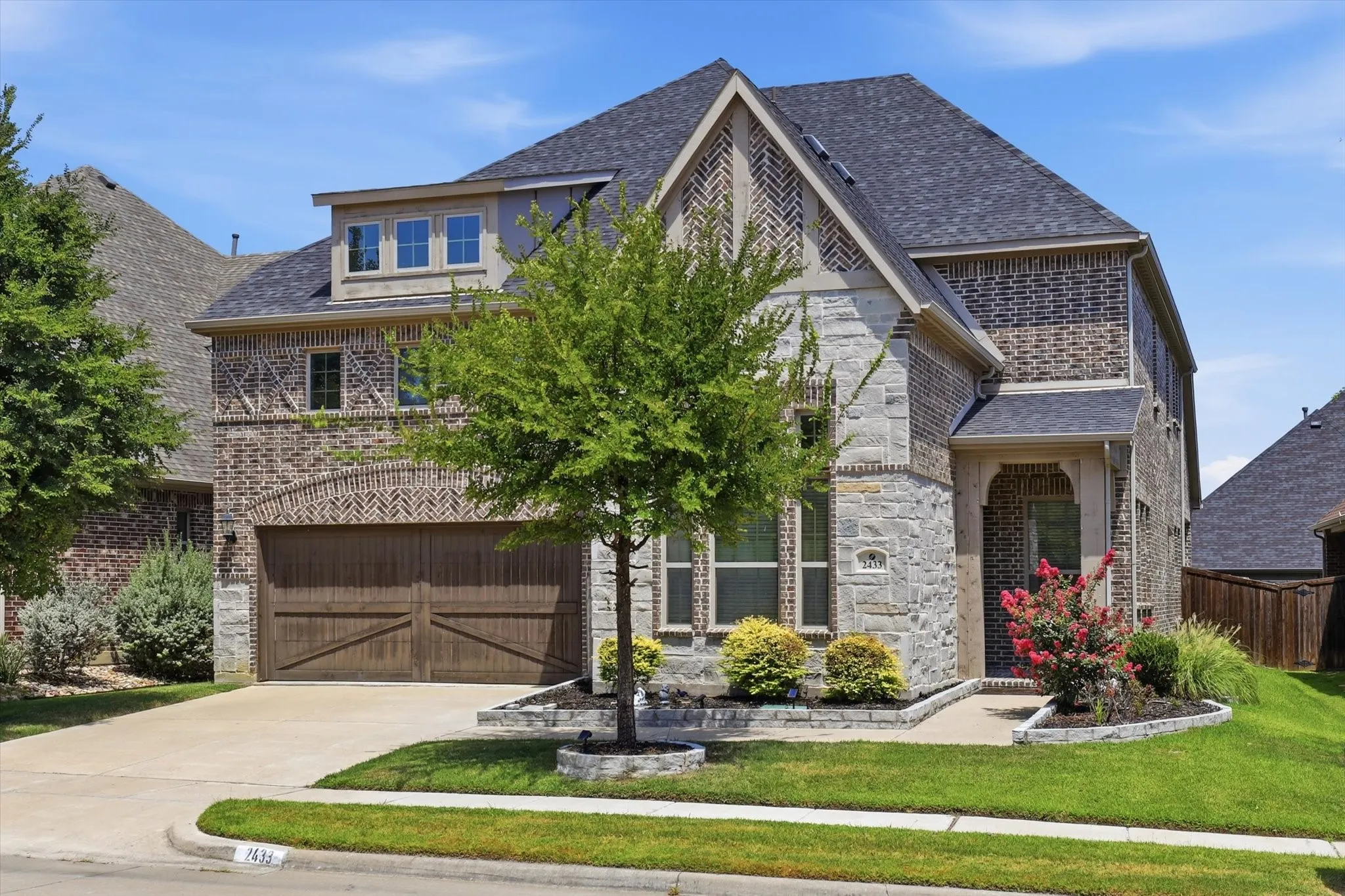 Gorgeous two story Stone and brick exterior with a two car garage.